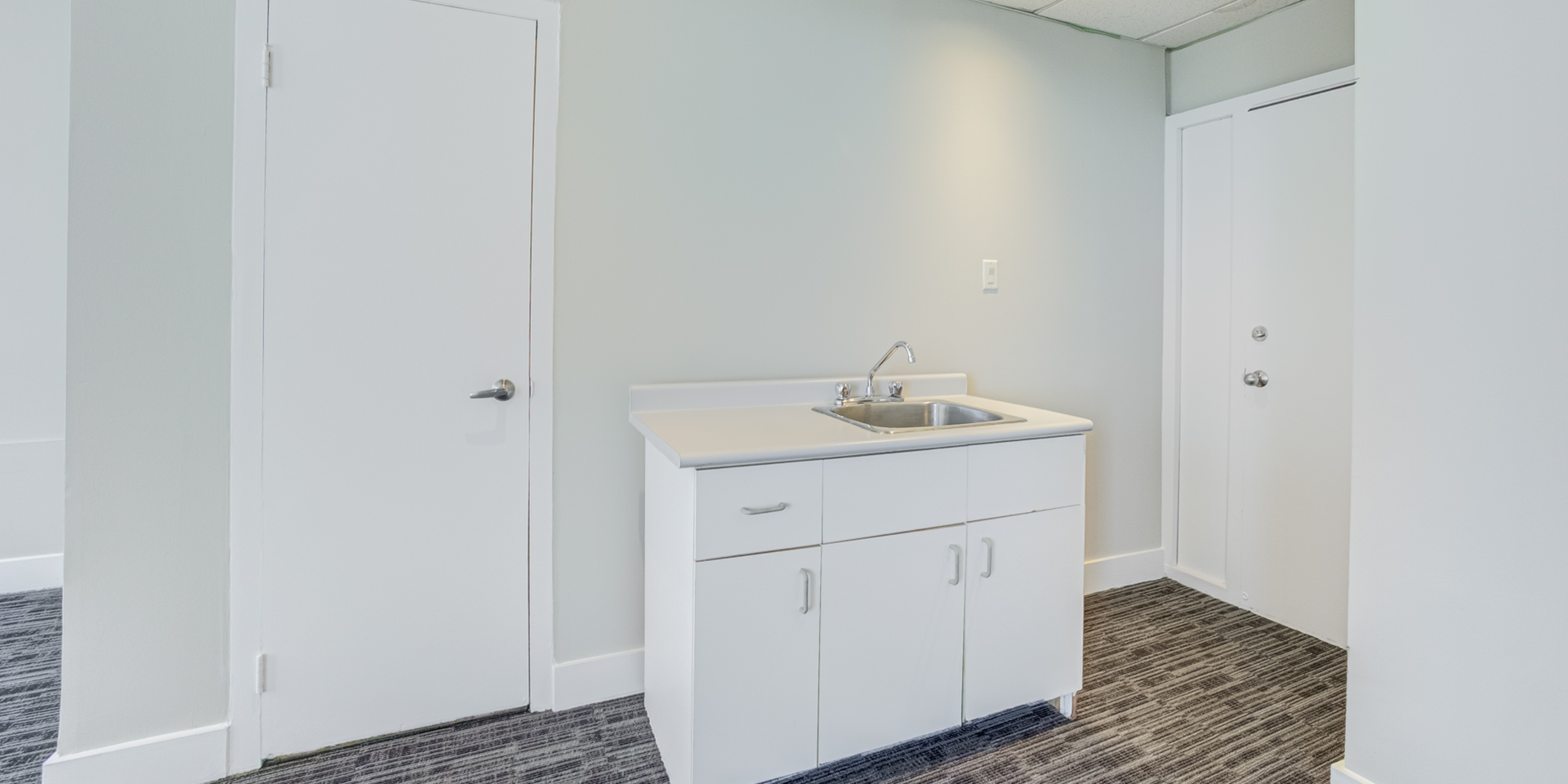 A room with a door and sink 801-60 Pleasant Boulevard