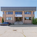 7669 Kimbel Street front view of two storey brick building with parking in front 