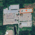 aerial of land site with property boundaries outlined in orange