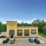 Front of standalone LCBO building with yellow brick and green awning
