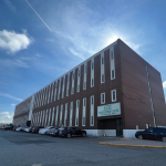 front of the building with parked cars surrounding it